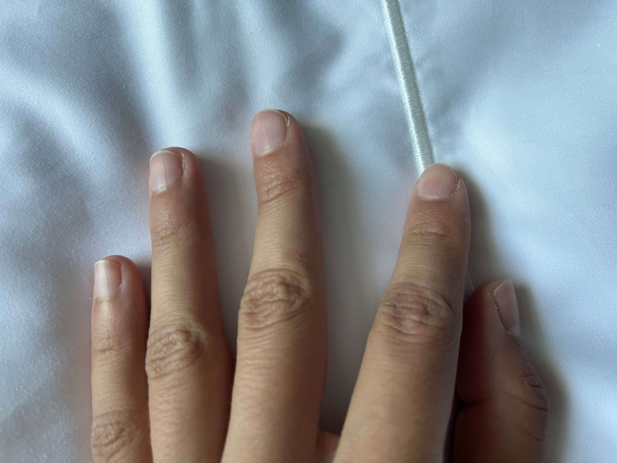 Dedos de uma mão numa fronha de algodão